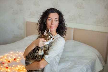 Young beautiful woman with cute cat resting at home. Domestic pet concept.の写真素材