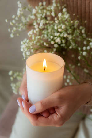 Woman holding burning candle. Womans hands and candle closeup.の写真素材