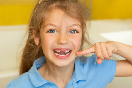 Beautiful little girl lost the first milk tooth. Happy child dropped the first milk tooth.