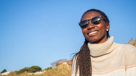 Young woman wearing sunglasses smiling on a sunny day