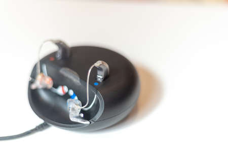 Detail of hearing aids on charger over white background