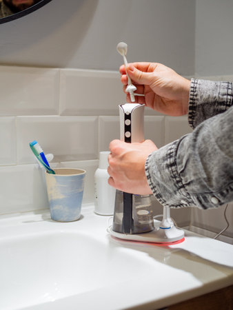 Young man hands changing his domestic dental water flosser tip