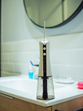<p>domestic dental water flosser on the bathroom wash basin</p>の写真素材
