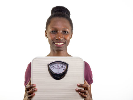 Young woman showing a weight scale isolated on white backgroundの写真素材