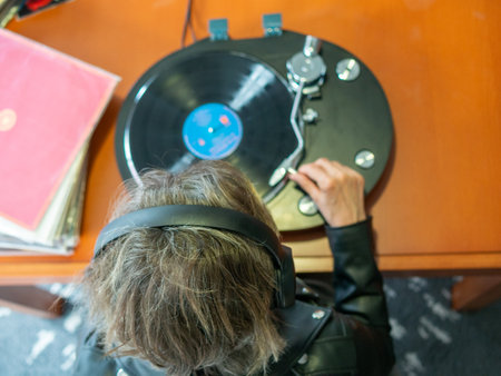 Lady hand holding the tonearm of her turntable ready to play a vinyl recordの写真素材