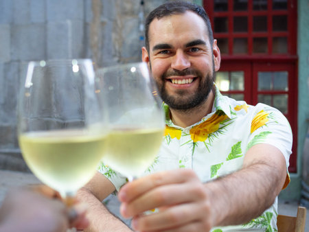 Young man drinking white wine in a street cafe in Barcelona, Spain