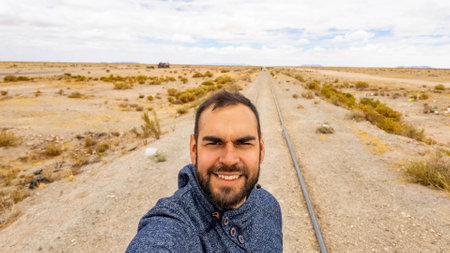 Bearded man tourist taking a selfie in an abandoned railway in Uyuni Bolivia