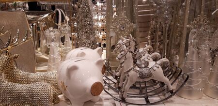 Warsaw, Poland, 12.01.2019: Golden holiday glass and porcelain decorations with rocking horses and piggy bankのeditorial素材