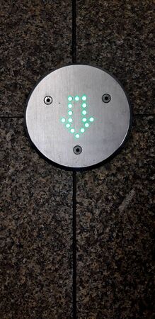 Warsaw, Poland, Dec 13, 2019: Green light dotted arrow sign showing direction on the floor of a metro stationのeditorial素材