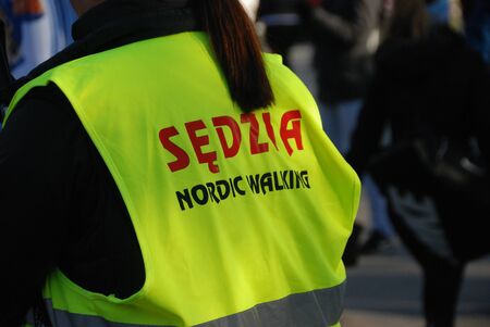 Warsaw, Poland - February 8, 2020: A female Nordic Walking instructor judge in a yellow vest