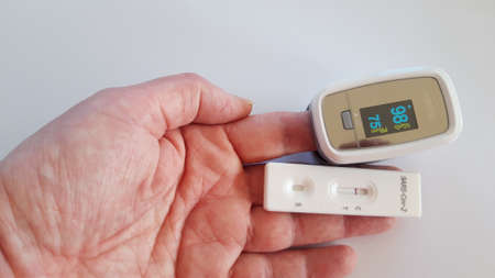 Hand with oxygen saturation measurement device and a negative COVID-19 test