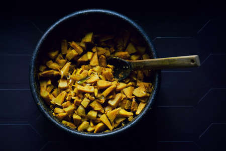 Stir fried breadfruit dish from Kerala, locally known as Kadachakka Mezhukkupuratti, served on a clay pot with wooden spatula. It's used as side dish for cooked rice.の写真素材