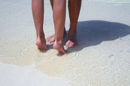 Couple is on the sandy beach in sunny dayの写真素材