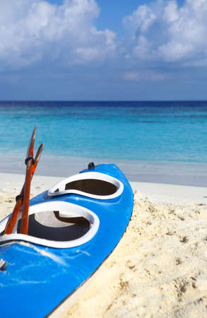 Paddle blue boat is on a sandy beachの写真素材