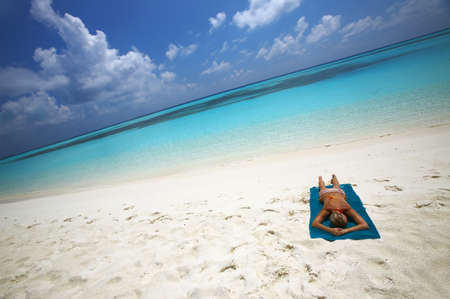 Young women is sunburning on the coast of the Indian Ocean, Maldivesの写真素材