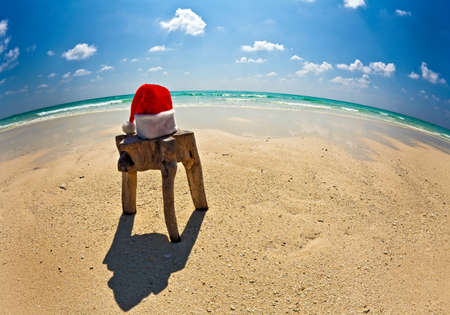 Santa hat is on an original stool  is made from trunk of tree , Maldives beachの写真素材