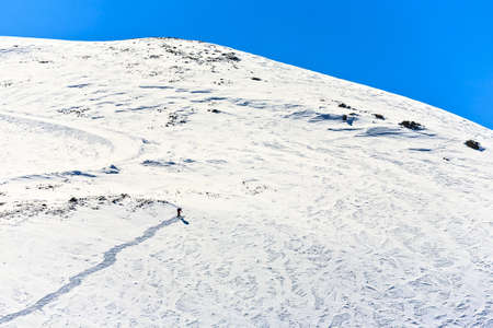 The lonely skier clambers on the mountain