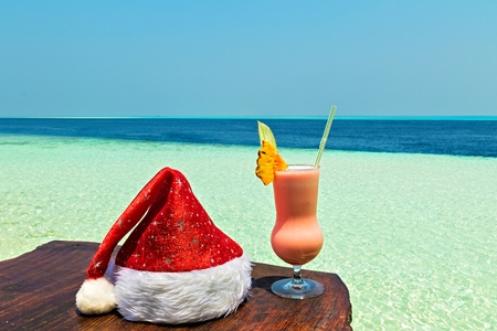 Bocal of drink is on a beach table with Santa hat (Maldives, The Indian Ocean)の写真素材