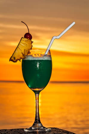 Glass of the soft drink is on a beach table (Maldives, The Indian Ocean)の写真素材