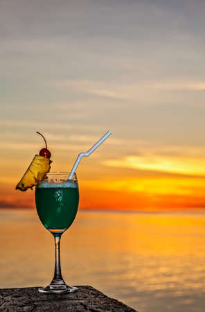 Glass of the soft drink is on a beach table (Maldives, The Indian Ocean)の写真素材