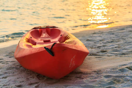 Red boat is on sandy sunset beach, Maldives