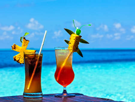 Two glasses of drink are on a beach table (Maldives, The Indian Ocean)の写真素材