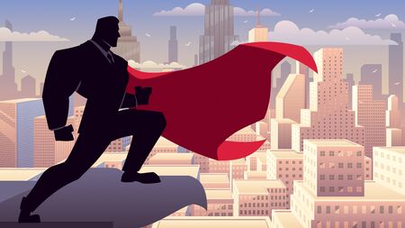 Super businessman watching over the city from the roof of a tall building.の写真素材