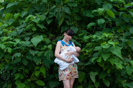 Girl, mother with a toddler on the background of a catalpa tree with fruits. Wallpaper, tree, catalpa.の写真素材