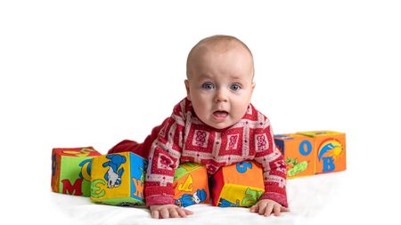 Little child, toddler, son playing with cubes, cognizing the world. A baby, lies on his tummy.の写真素材
