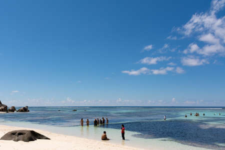 La Digue, Seychelles - 3rd December, 2016: Tourists and beach goers enjoying a nice sunny day on the beach of Anse Source D'Argent, one of the most photographed beaches in the world.のeditorial素材