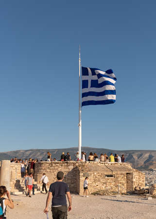 Athens, Greece - 13th October, 2019: The National Flag of Greece is flying on the far east side of the Acropolis, while tourists take in the views of the city of Athens.のeditorial素材