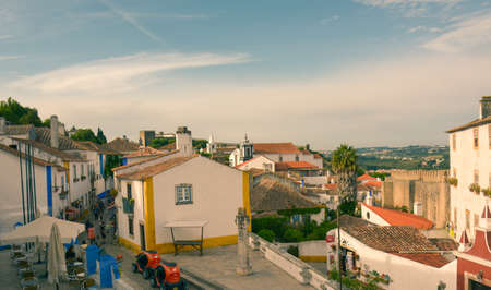 Obidos, Portugal - 16th May, 2017: Tourists exploring the narrow cobbled stone streets of the medieval town of Obidos in Portugal.のeditorial素材