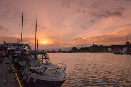 Beautiful vistas as the sunsets on the harbour at Bergen in Norway. Boats moored in the port.の写真素材