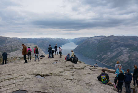Rogaland, Norway - 23rd May, 2017: Hikers enjoying the beautiful views of the Lysefjord on an overcast day from the Pulpit rock, Norway. Also called Preikestolen or Preacher's pulpit.のeditorial素材