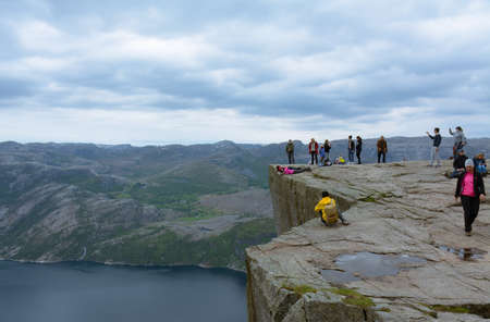 Rogaland, Norway - 23rd May, 2017: Hikers being brave and taking pictures while posing on the edge of the Pulpit rock, Norway. Also called Preikestolen or Preacher's pulpit.のeditorial素材
