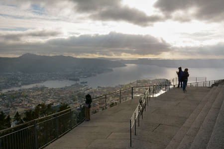 Bergen, Norway - 24th May, 2017: Tourists taking in the views of the city of Bergen from an observation deck atop Mount Floyen on a hazy summer afternoon.のeditorial素材