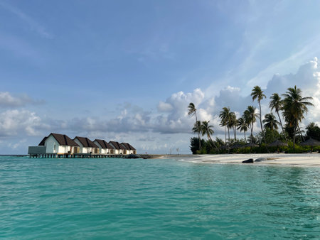 Beautiful views of a tropical island with water villas in the distance from the turquoise waters of the Maldives. Exotic tourism concept.の写真素材