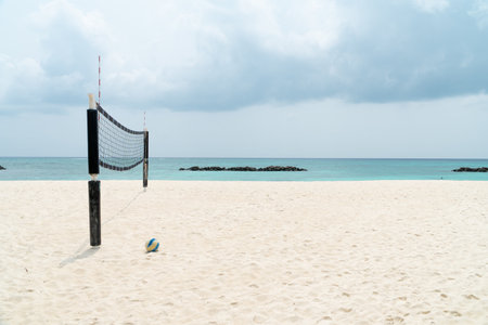 view of a beach volleyball court with the net tied up and the ball on the sand on a clear sunny day on a tropical island in the maldives.の写真素材
