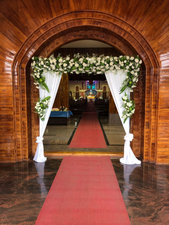 Church entrance decorated with beautiful white flowers for the wedding ceremony.の写真素材