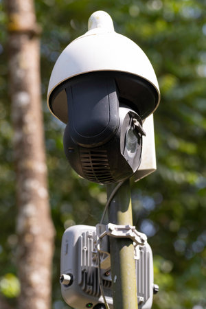 Close-up of a CCTV surveillance camera mounted on a metal in the yard.