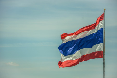 Thai flag waving with blue sky backgroundの写真素材