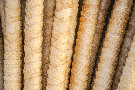 Stacks of various type of golden brown crispy ice cream cones texture background