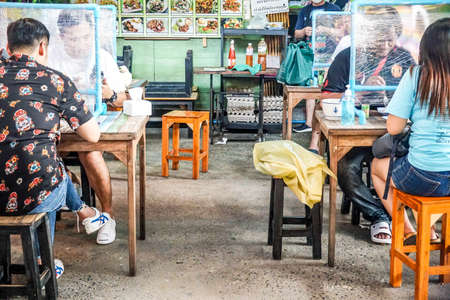 A local restaurant in Bangkok sets plastic partitions to help customers to eat together by sharing same table safely  from virus spreading, Bangkok, Thailand, 5 May 2020のeditorial素材