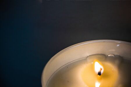 A lighted candle among darkness. Life and hope concept backgroundの写真素材