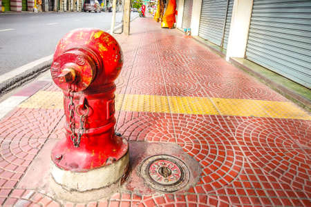 Old red public fire hydrant faucet on public pavement in Bangkok, Thailandのeditorial素材