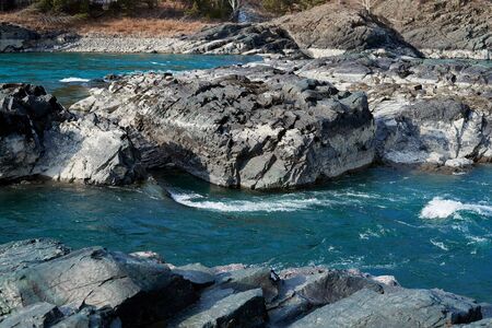 Emerald water of mountains river with rocks. Bubbling stream of river Katun in Altai Republic