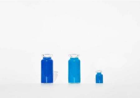 Some test tube with blue water of different shade. They are on a white background. Test tube are different size.の写真素材