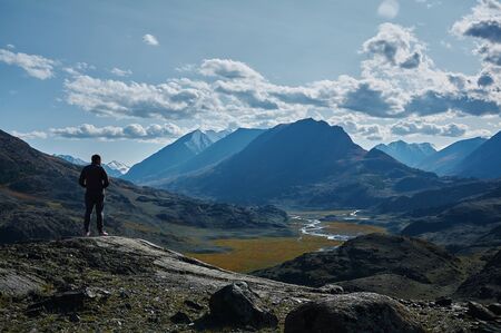 Tourist looks at gorgeos landscape of mountains. Altai mountains, Siberia. Travel and active lifestyle conceptの写真素材