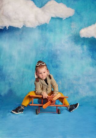 Dreams of travel. Funny child flying on the sky with cloudsの写真素材