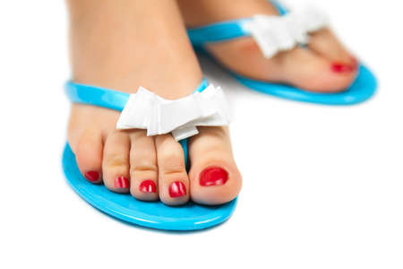 Female foot with pedicure in blue slippers on a white background